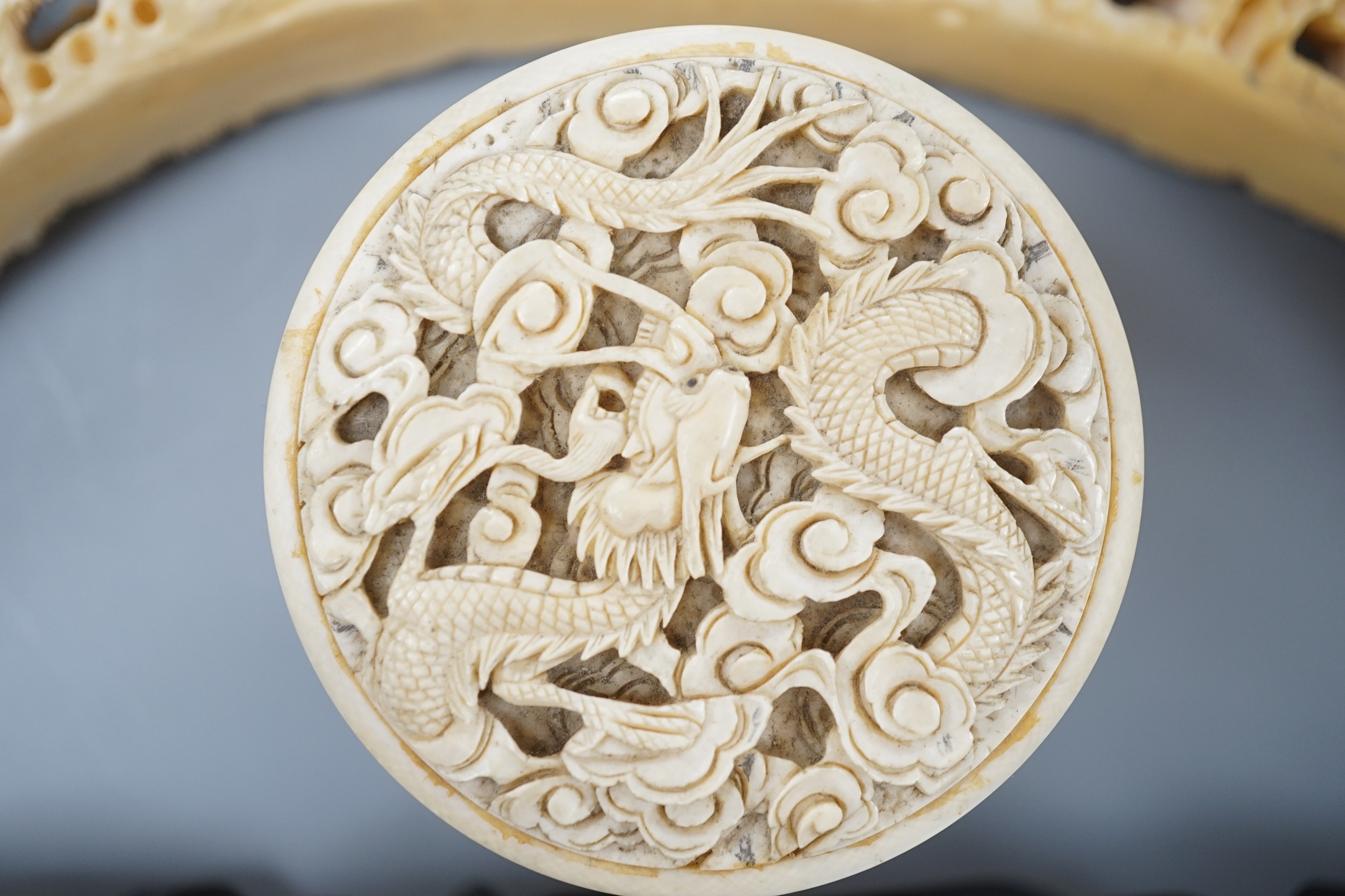 An early 20th century Chinese ivory ‘dragon’ box and cover, and a boar’s tusk carving of figures amid pavilions 40cm